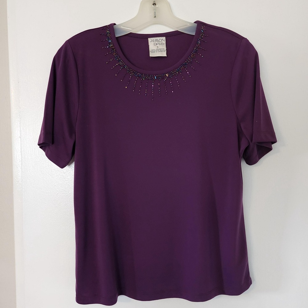 S plum colored short sleeve top with colorful beading around collar